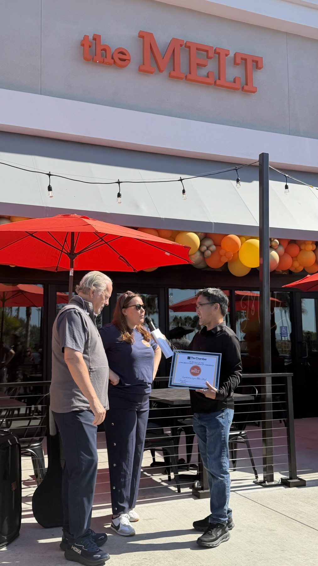 Stuart Takehara presents a Chamber of Commerce certificate to The Melt representatives during the restaurant’s Long Beach grand opening